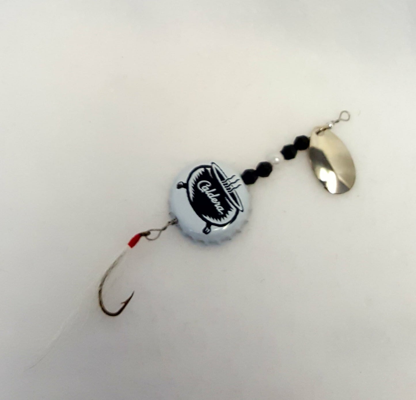 Lure has a white bottle cap with a cauldron, black & white beads, and white fly.
