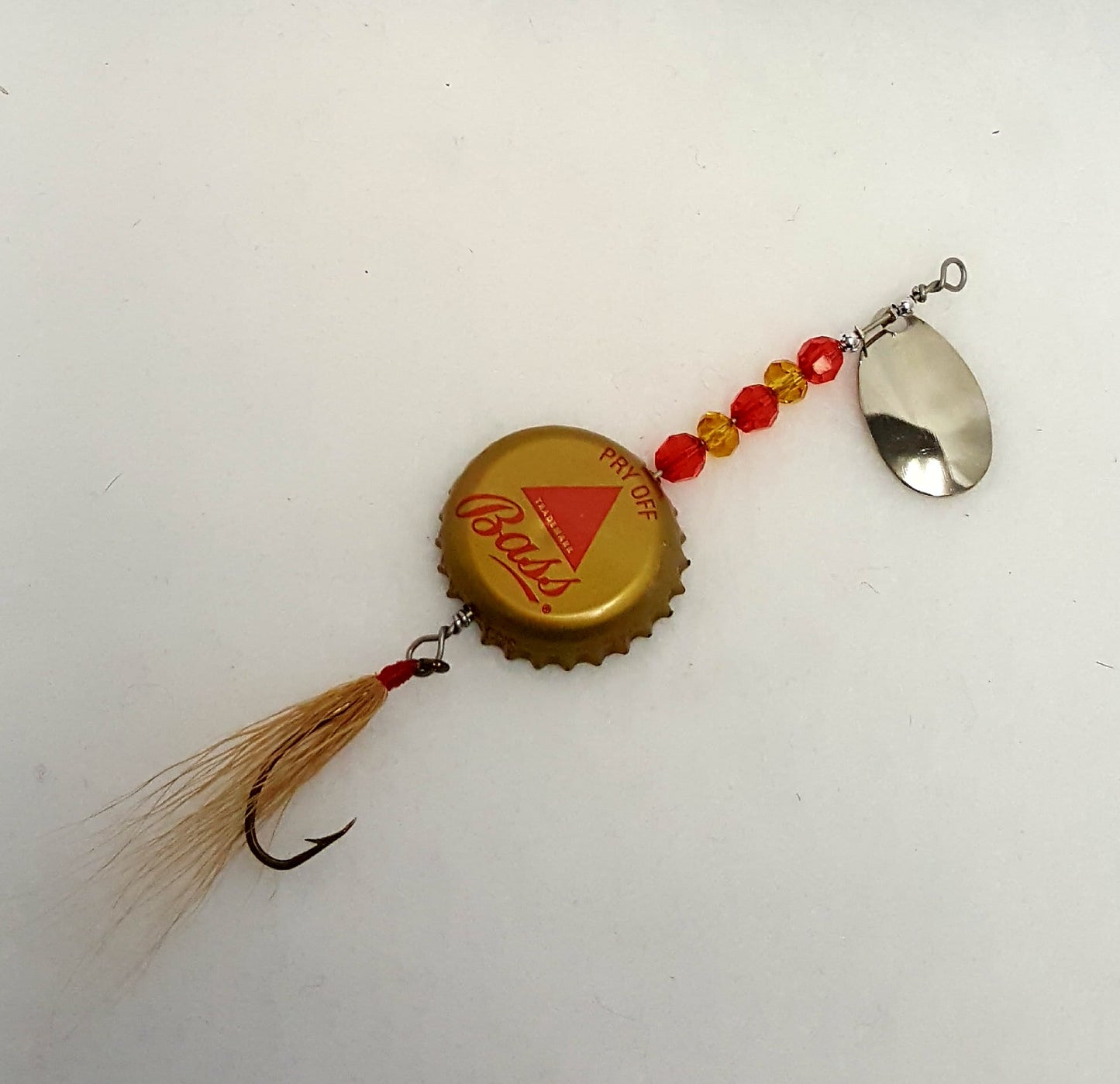 Lure has a gold bottle cap with red triangle, red & gold beads, and gold fly.