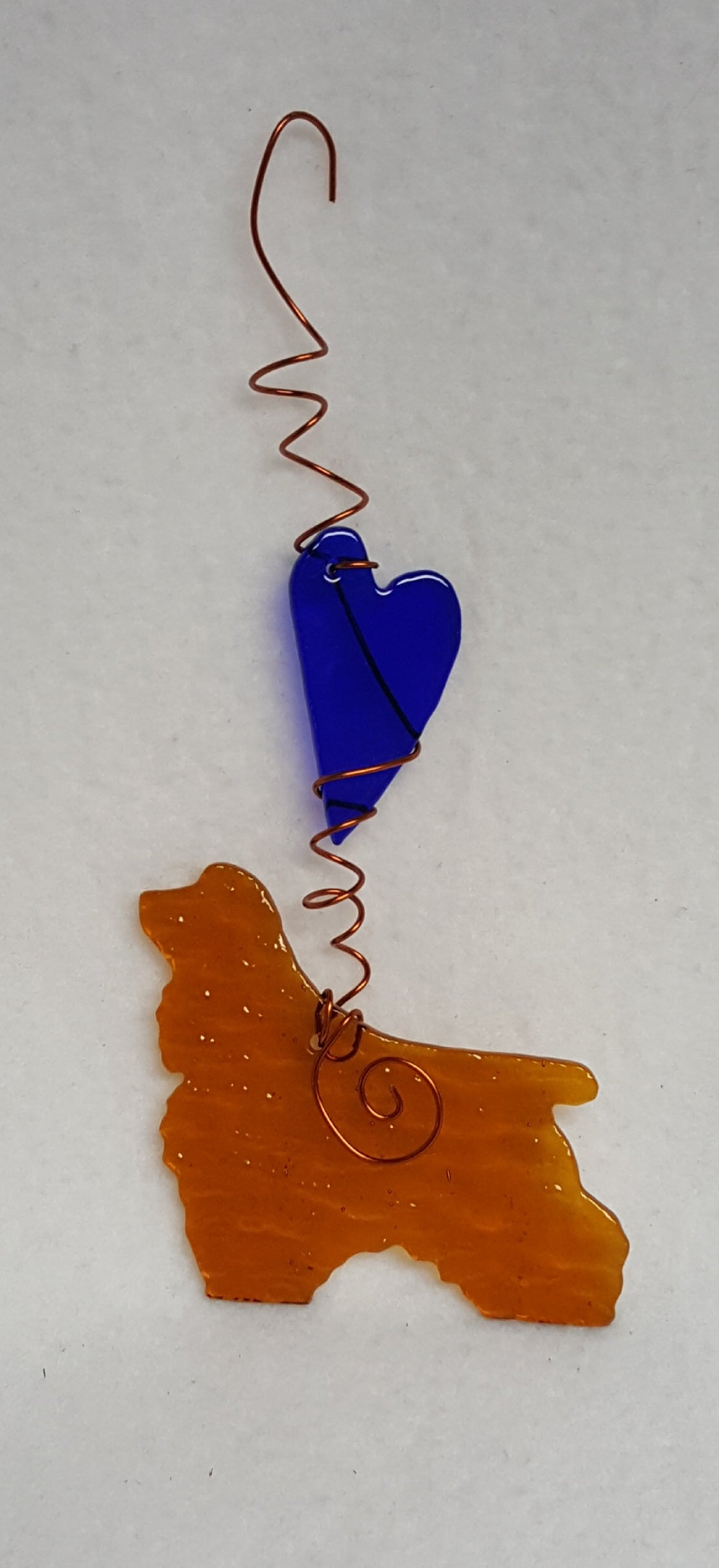 An apricot colored cocker spaniel with a deep blue heart. Suncatcher hangs 7.5 inches.