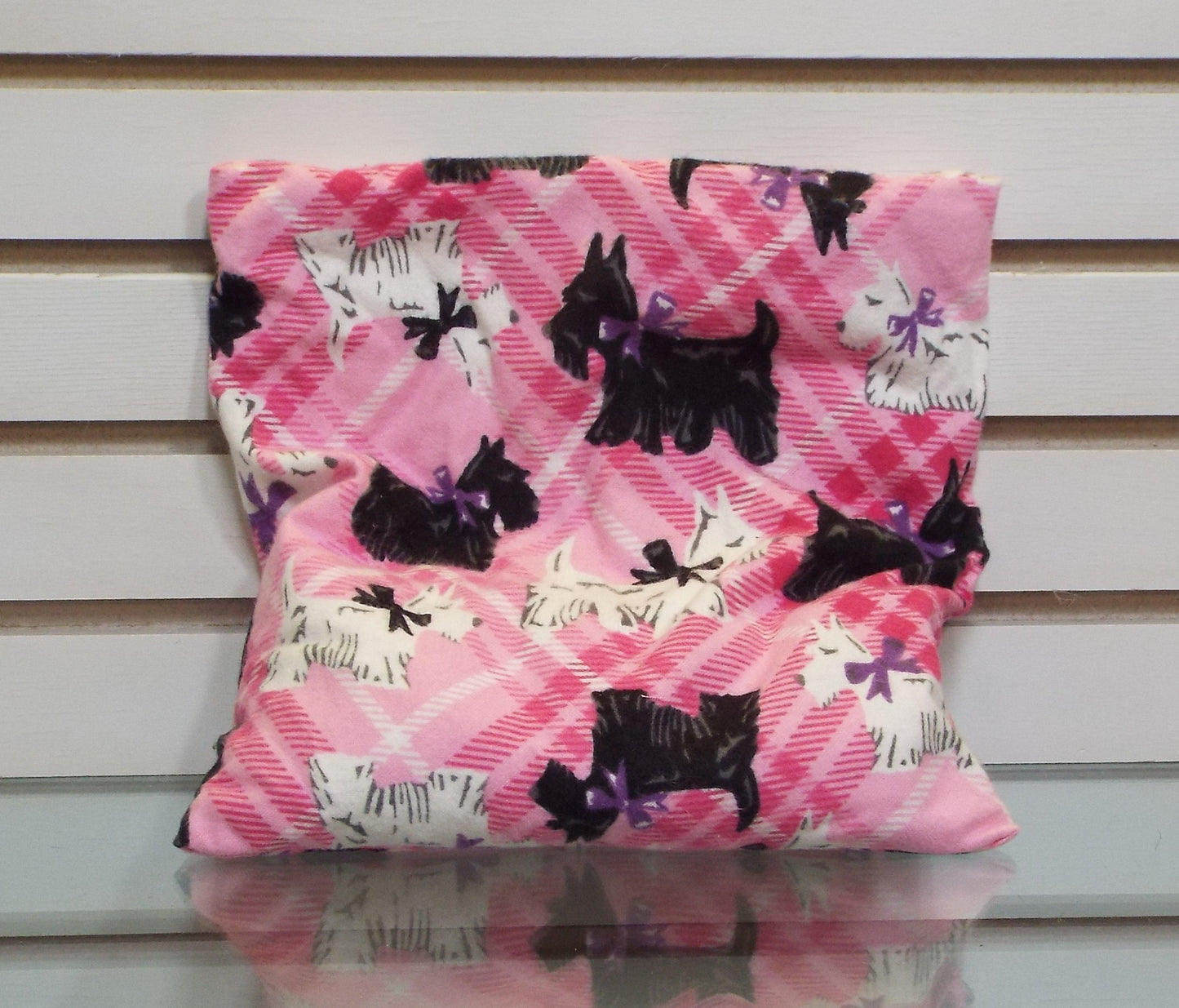 Pink tartan slip cover adorned with white West Highland Terriers and clack Scottish Terriers.